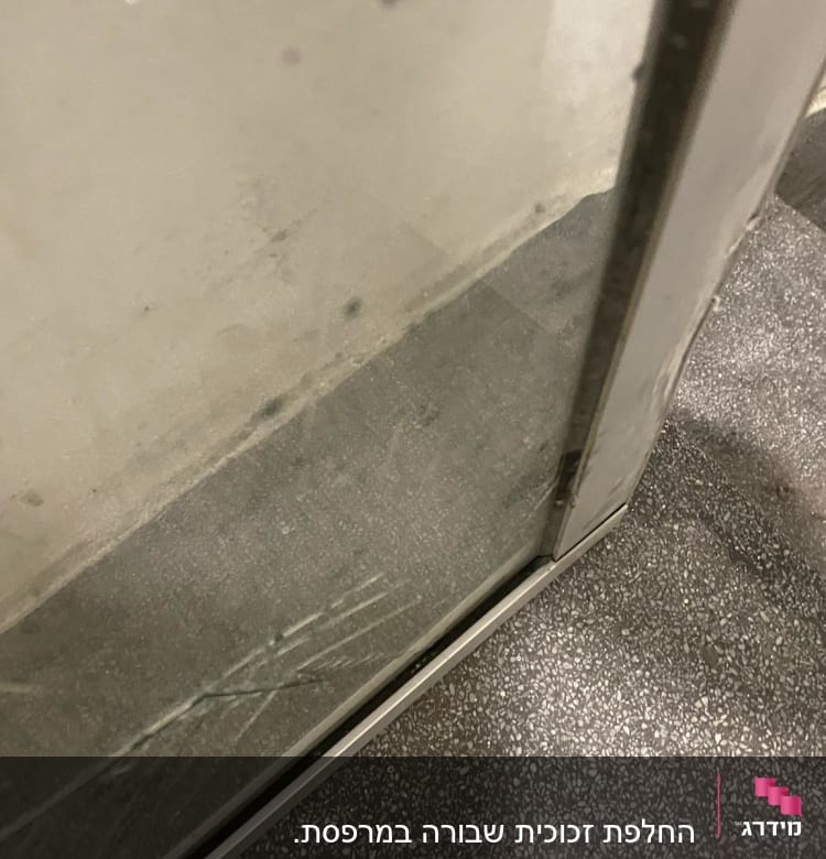 זכוכית עם שריטות במסגרת מתכת ליד מדרגות